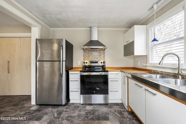 kitchen with wall chimney exhaust hood, white cabinetry, stainless steel appliances, and a sink