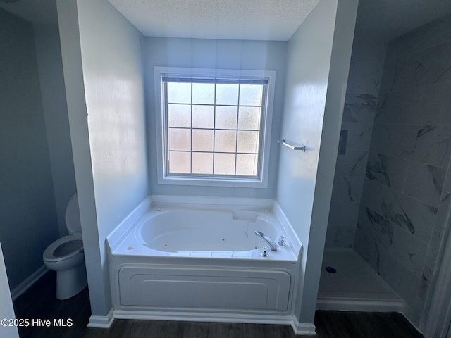 bathroom featuring baseboards, toilet, a textured ceiling, a walk in shower, and a bath