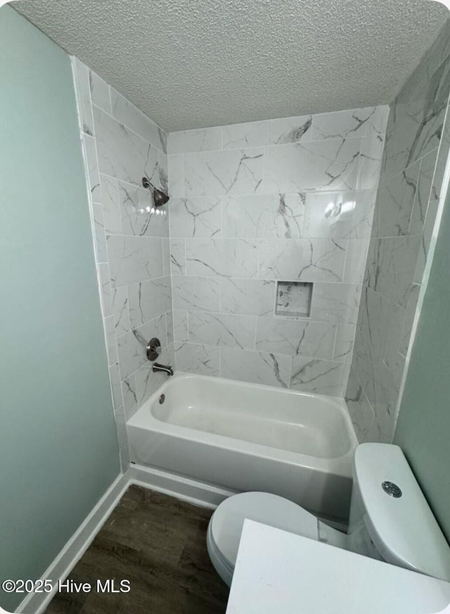 full bathroom with baseboards, toilet, shower / tub combination, wood finished floors, and a textured ceiling