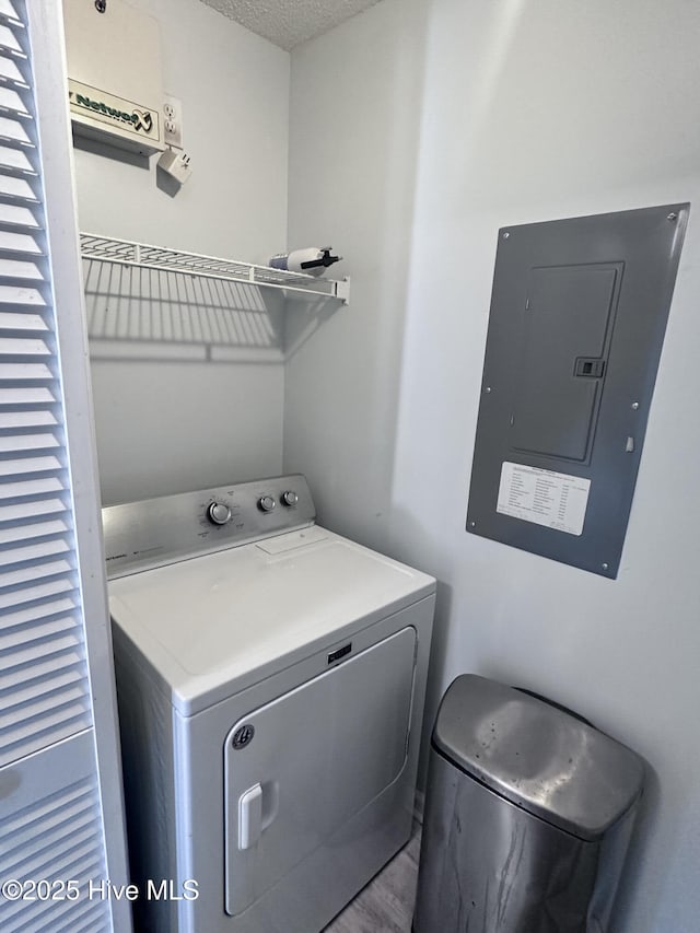 laundry area featuring washer / dryer, electric panel, laundry area, and a textured ceiling