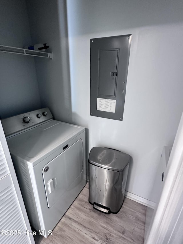 clothes washing area featuring washer / dryer, laundry area, electric panel, and light wood-style floors