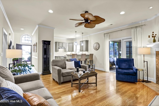 living room with ceiling fan, recessed lighting, baseboards, light wood finished floors, and crown molding