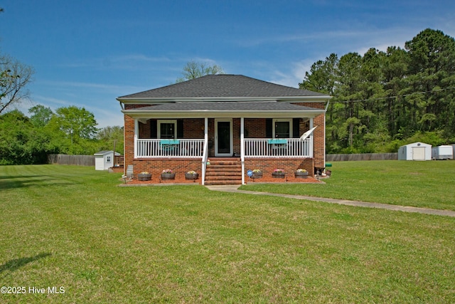 bungalow with a storage shed, a front lawn, covered porch, and brick siding