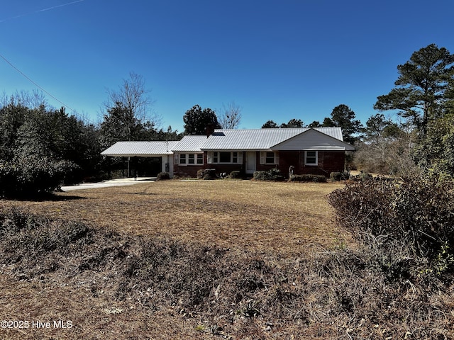 view of front of property featuring a carport and metal roof