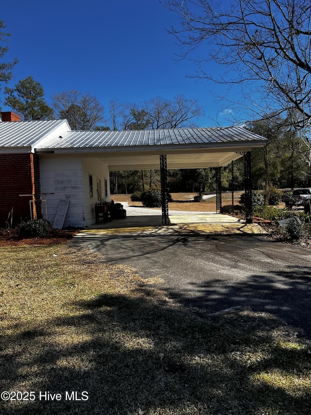 view of parking / parking lot featuring driveway and an attached carport