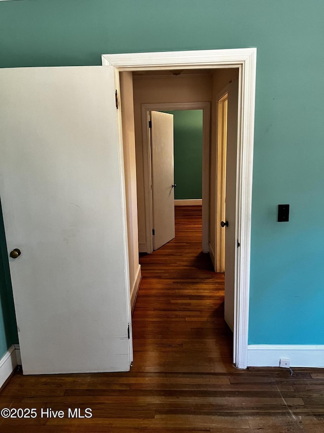 hall featuring dark wood-style floors and baseboards