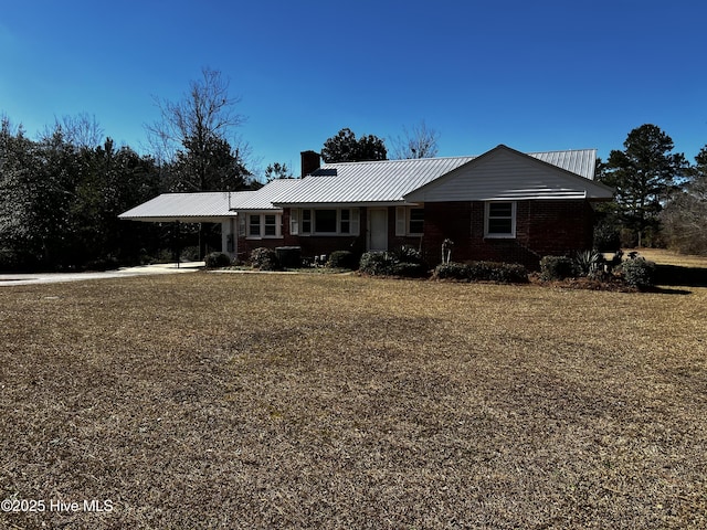 ranch-style home featuring metal roof, a chimney, and a front lawn