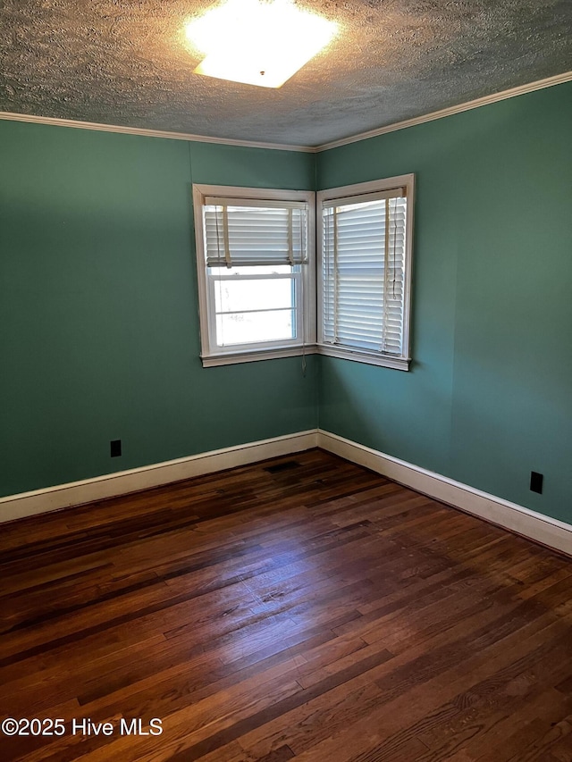 unfurnished room with dark wood-style flooring, crown molding, a textured ceiling, and baseboards