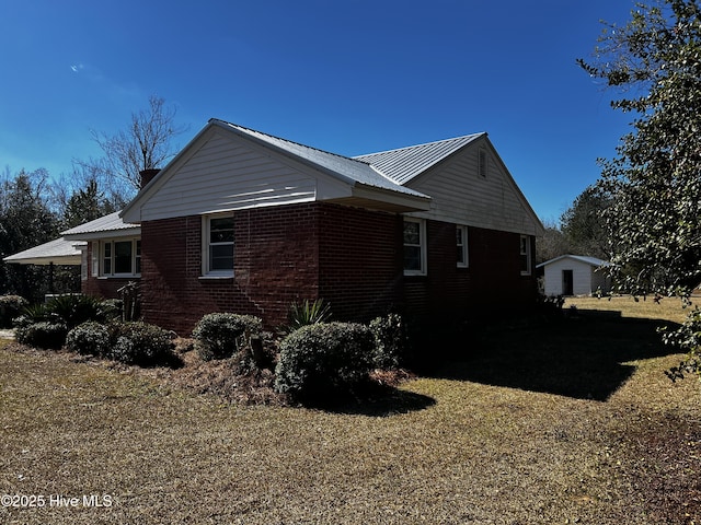 view of property exterior with brick siding and metal roof