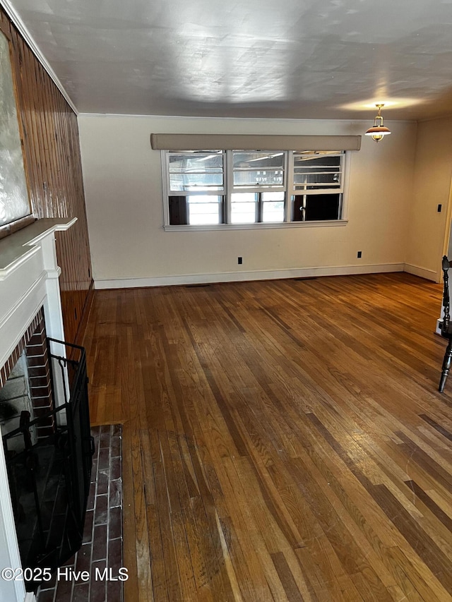 unfurnished living room featuring a fireplace, wood finished floors, and baseboards