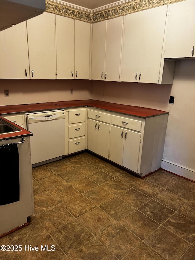 kitchen with dark countertops, white cabinets, and white dishwasher