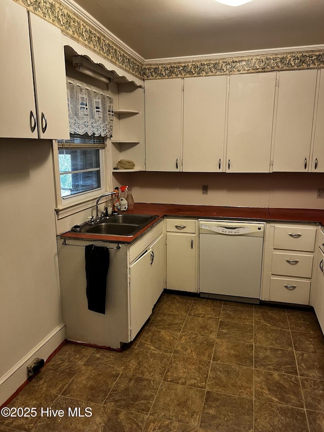 kitchen featuring dark countertops, white dishwasher, white cabinets, and a sink