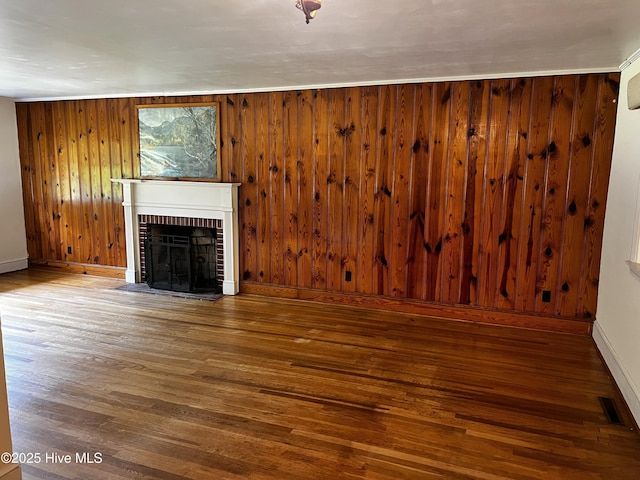 323 Hoover Rd, White Oak, NC 28399 - unfurnished living room featuring a brick fireplace, wood finished floors, wooden walls, and baseboards