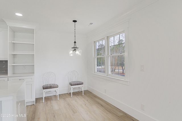 unfurnished room featuring visible vents, baseboards, an inviting chandelier, crown molding, and light wood-type flooring