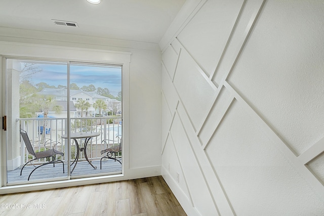 interior space with light wood-style flooring, visible vents, and baseboards