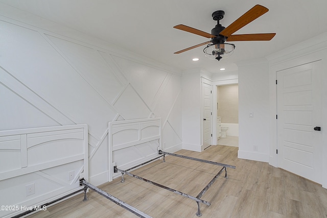 interior space with connected bathroom, recessed lighting, a decorative wall, a ceiling fan, and light wood finished floors