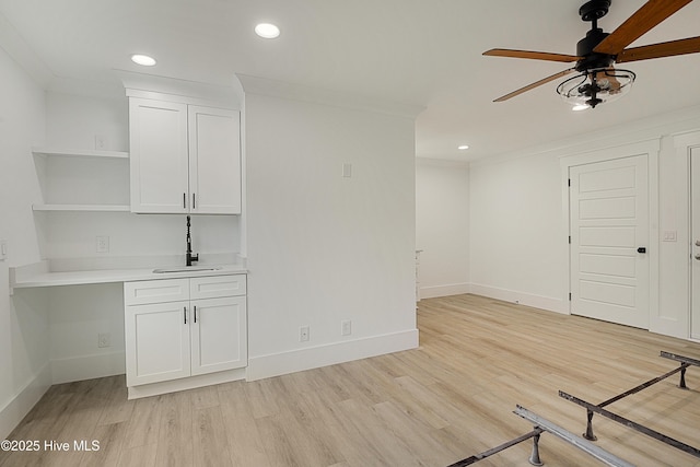 unfurnished living room featuring baseboards, crown molding, and light wood finished floors