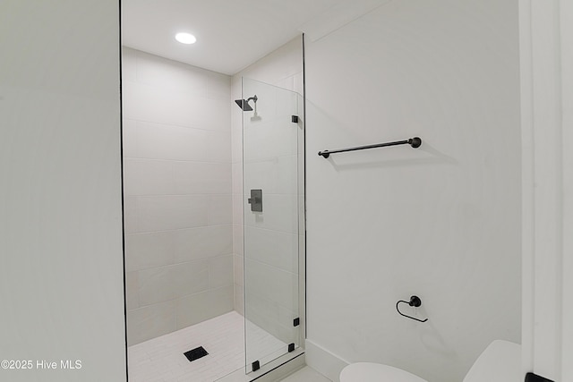 bathroom featuring toilet and a shower stall