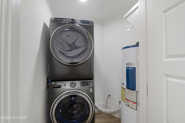 laundry area with water heater and stacked washer / drying machine