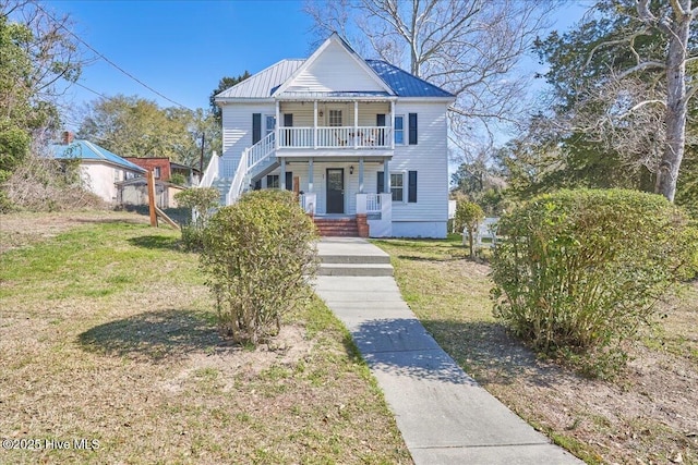 view of front facade featuring metal roof, a porch, and a front yard