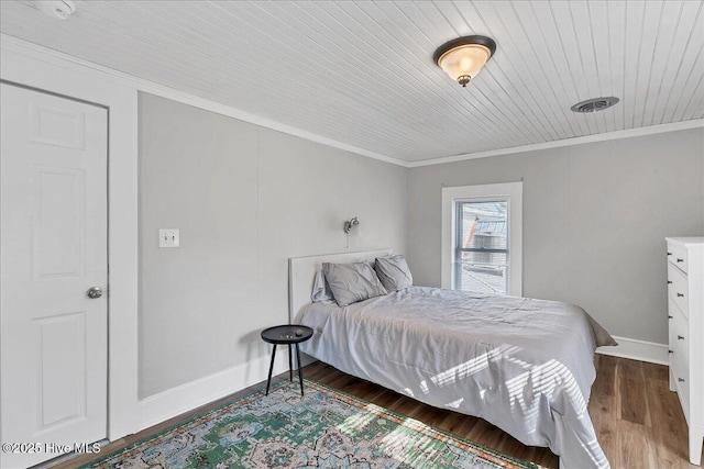 bedroom featuring wooden ceiling, crown molding, baseboards, and wood finished floors