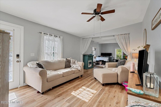 living area with light wood-type flooring, ceiling fan, and lofted ceiling