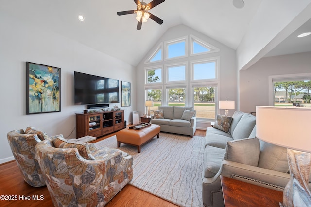 living room with a healthy amount of sunlight, high vaulted ceiling, a ceiling fan, and wood finished floors