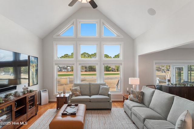 living room with light wood-style flooring, baseboards, high vaulted ceiling, and ceiling fan