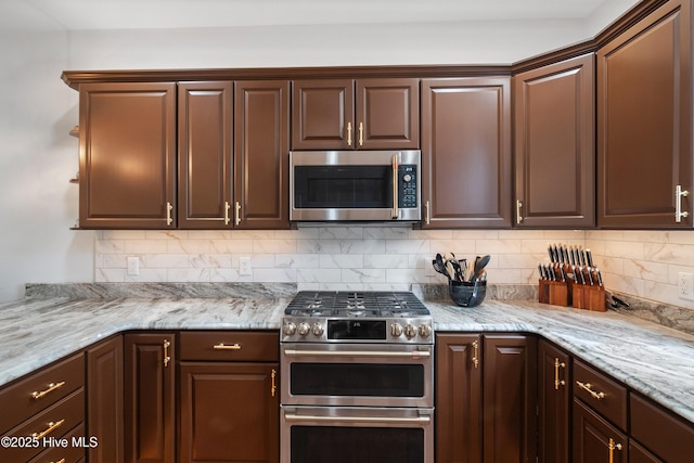 kitchen featuring dark brown cabinets, backsplash, stainless steel appliances, and light stone countertops