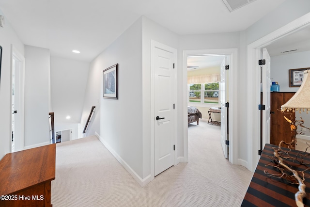 corridor featuring visible vents, baseboards, an upstairs landing, light carpet, and recessed lighting