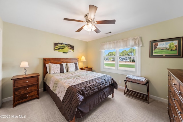 bedroom featuring visible vents, baseboards, light carpet, and a ceiling fan