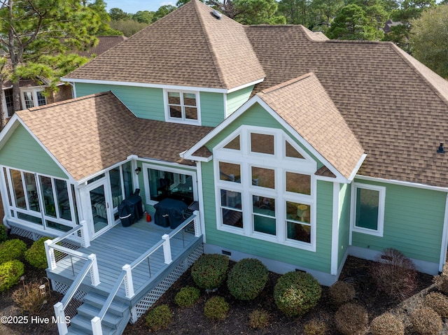 back of property featuring stairs, roof with shingles, and a sunroom