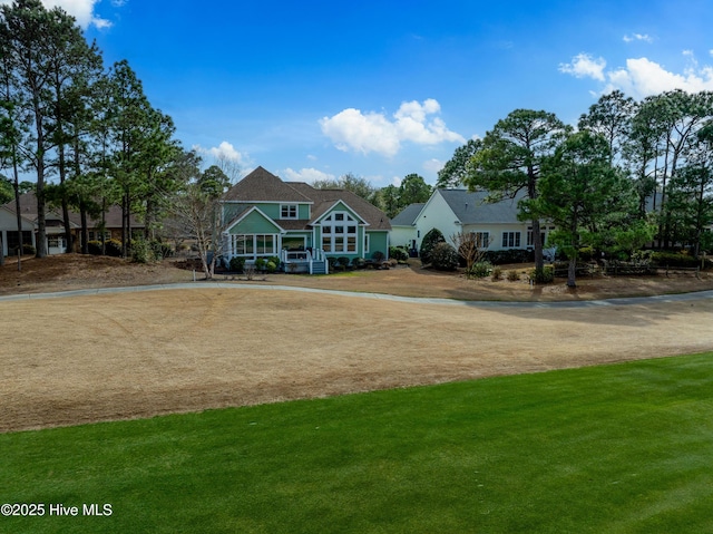 shingle-style home featuring a front yard