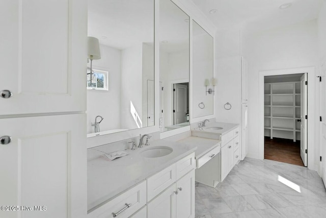 full bath with marble finish floor, a spacious closet, and vanity