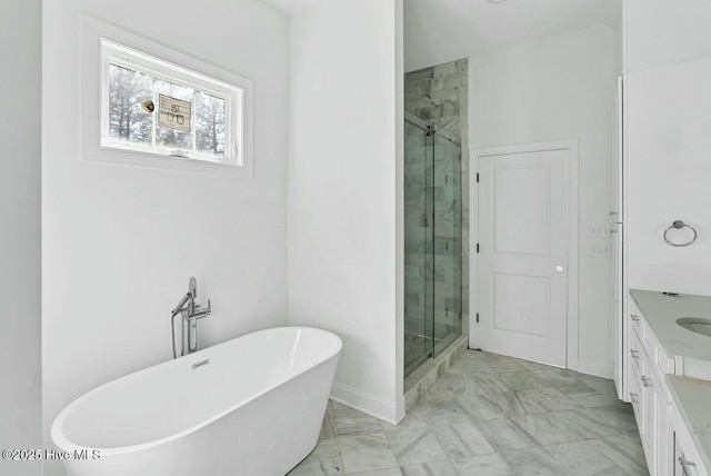 bathroom featuring a stall shower, baseboards, marble finish floor, vanity, and a freestanding tub