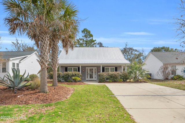 view of front of property featuring metal roof, french doors, and a front lawn