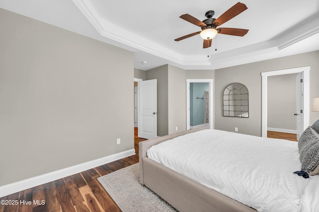 bedroom featuring wood finished floors, a raised ceiling, a ceiling fan, and baseboards