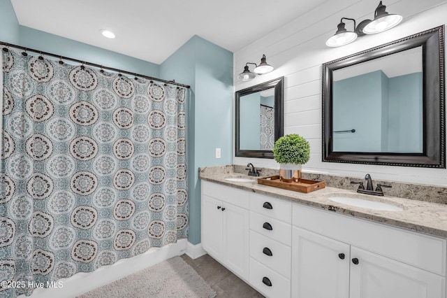 bathroom featuring double vanity, a shower with shower curtain, a sink, and tile patterned floors