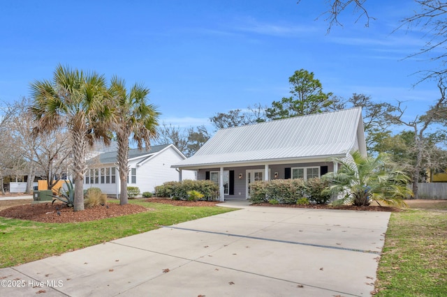 view of front of home featuring a porch, metal roof, and a front lawn