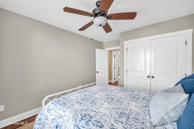 bedroom with a ceiling fan, a closet, baseboards, and wood finished floors