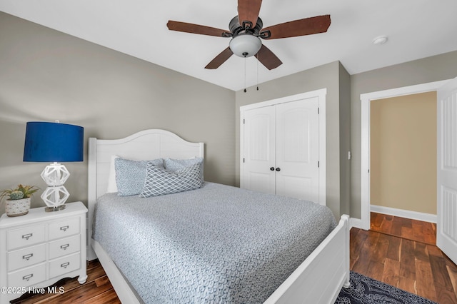 bedroom featuring ceiling fan, dark wood-type flooring, a closet, and baseboards