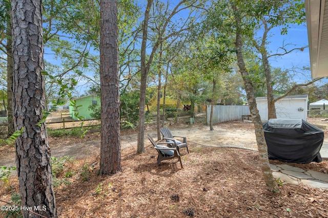 view of yard with a fire pit and fence