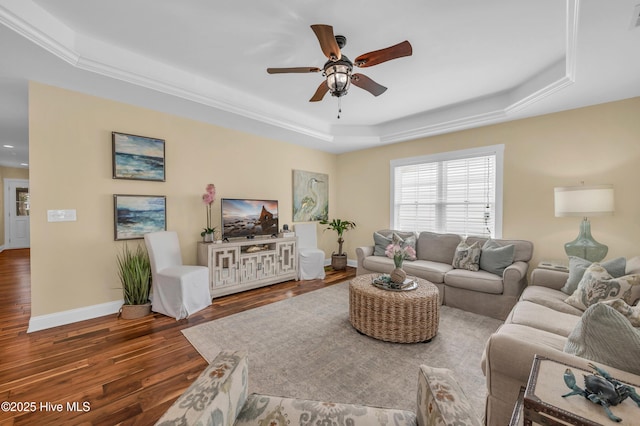 living room featuring baseboards, visible vents, ceiling fan, wood finished floors, and a tray ceiling