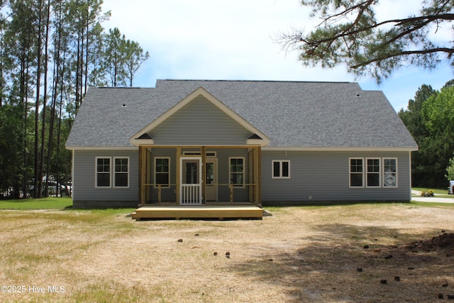 104 Backfield Dr, Newport, NC 28570 - rear view of house featuring a shingled roof, a lawn, and a deck