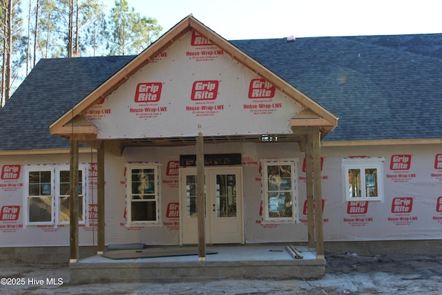 property in mid-construction with a shingled roof