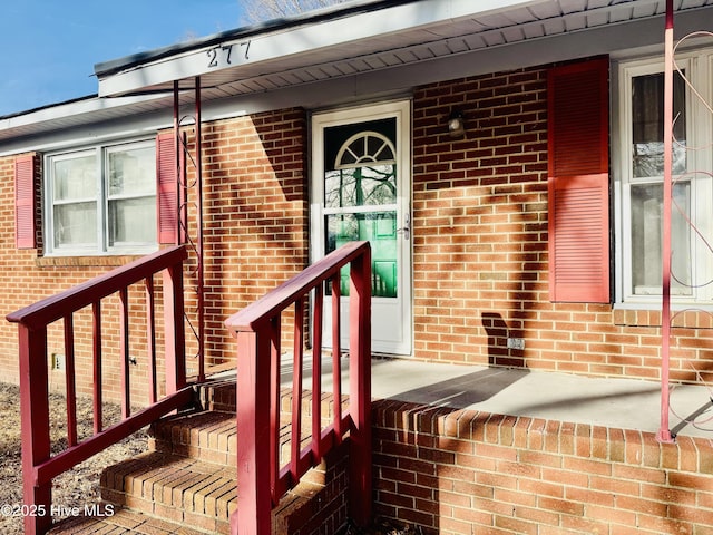 doorway to property featuring brick siding