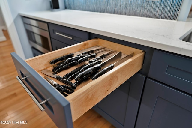 room details with tasteful backsplash, light countertops, and wood finished floors