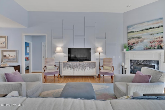 living room featuring light wood-style flooring and a high end fireplace