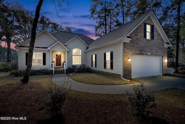 traditional home with a garage, concrete driveway, and brick siding