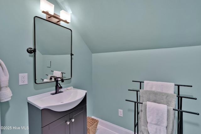 bathroom with vaulted ceiling and vanity